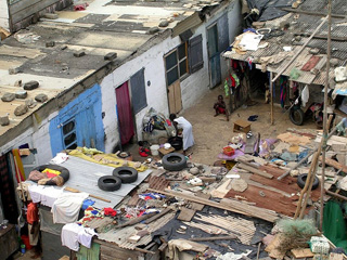 Photo of a group of flimsy makeshift housing for poor families in Ghana.