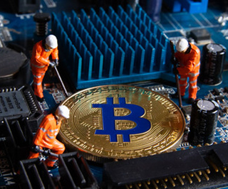 A golden coin sits on a motherboard. Three mini figurines surround the coin with tools.